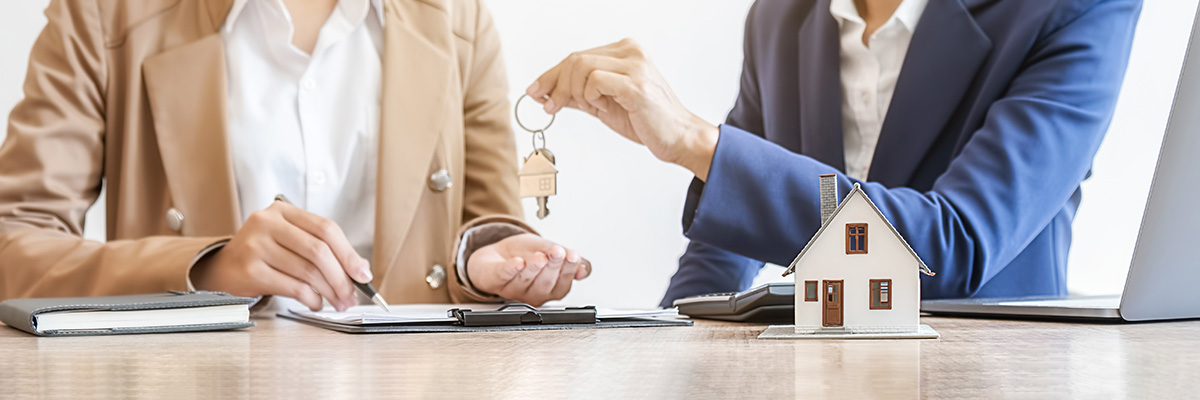 Real estate agent holding a key and asking costumer for contract