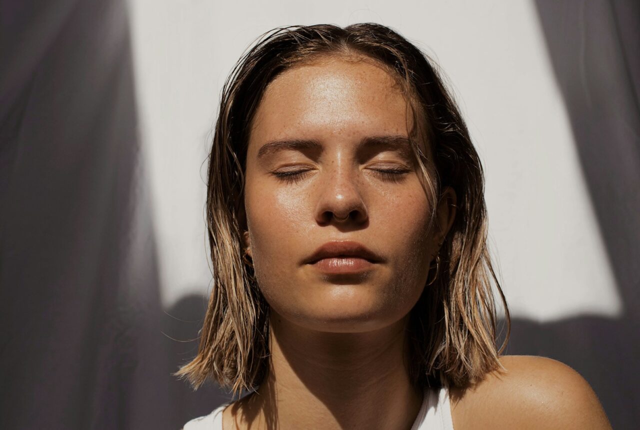 Woman applying moisturiser to damp facial skin, the key step in rehydrating a dehydrated skin barrier