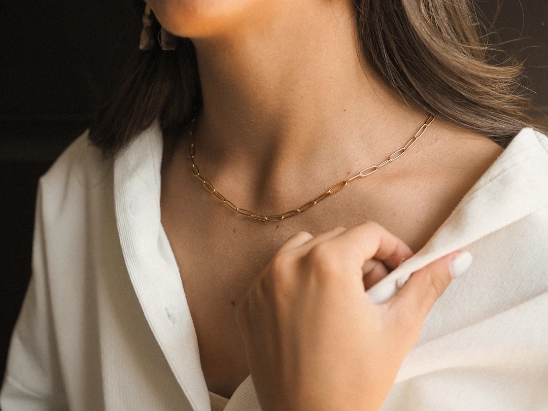 Woman in a crisp white shirt wearing a dainty gold necklace — best jewelry for Virgo women