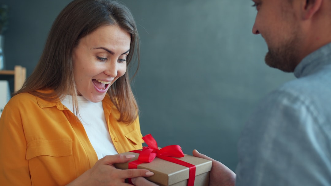 Excited young woman receiving a birthday gift from her boyfriend — birthday gifts for girlfriend