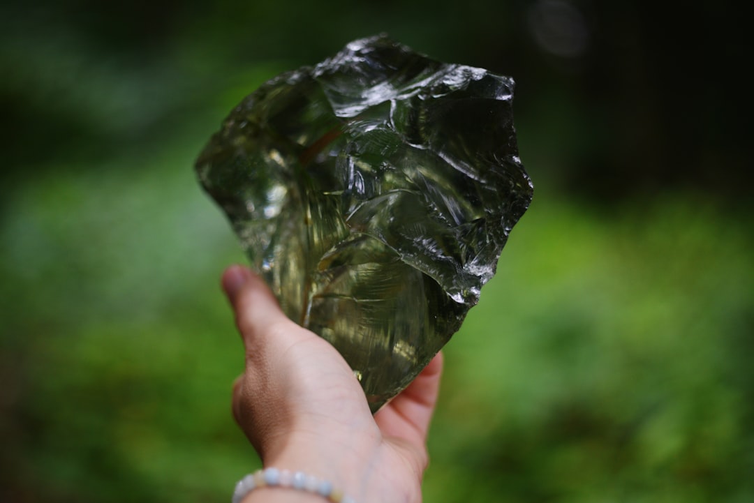 Hand holding a piece of black obsidian, a protective gemstone for Scorpio in love