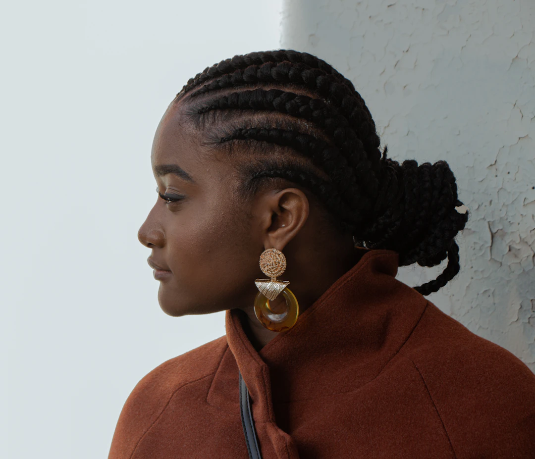 Woman wearing bold gold statement earrings — individualist style suits Aquarius women