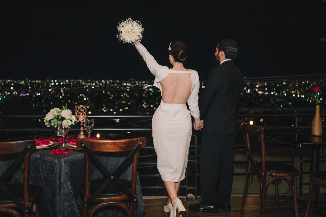 Elegant couple on a balcony overlooking the city at night, embodying the ambitious Capricorn soulmate bond