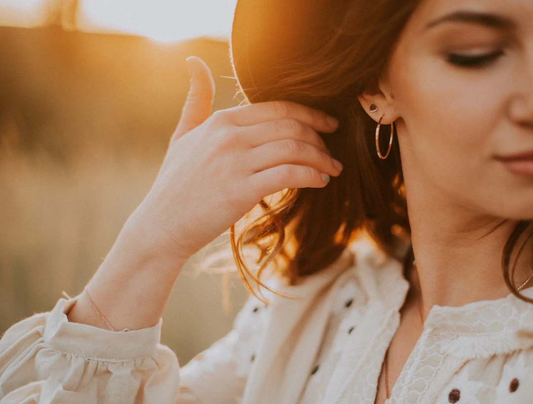 Confident woman wearing gold jewelry — energetic statement style suits Aries women