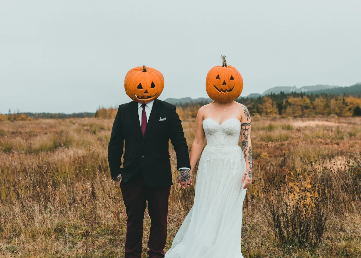 Couple wearing matching pumpkin-head Halloween costumes