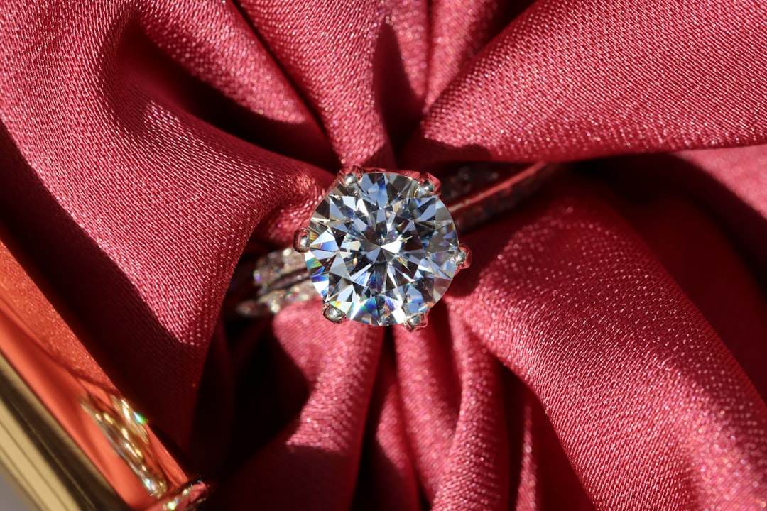 Diamond solitaire ring on red textile — diamond as a 10th anniversary gift