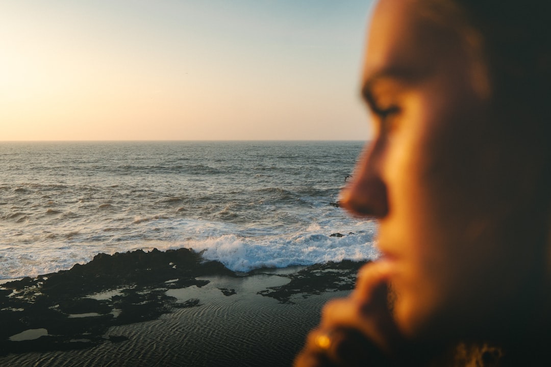 Woman gazing at the ocean at sunset reflecting the dreamy Pisces nature