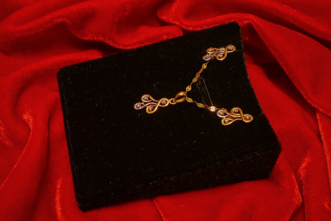 Gold and diamond pendant and earrings set displayed on a velvet box for a diamond anniversary gift