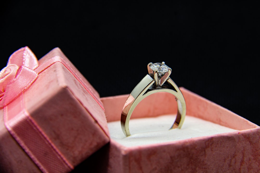 Gold ring set with a diamond in a pink gift box — a 50th birthday jewelry gift