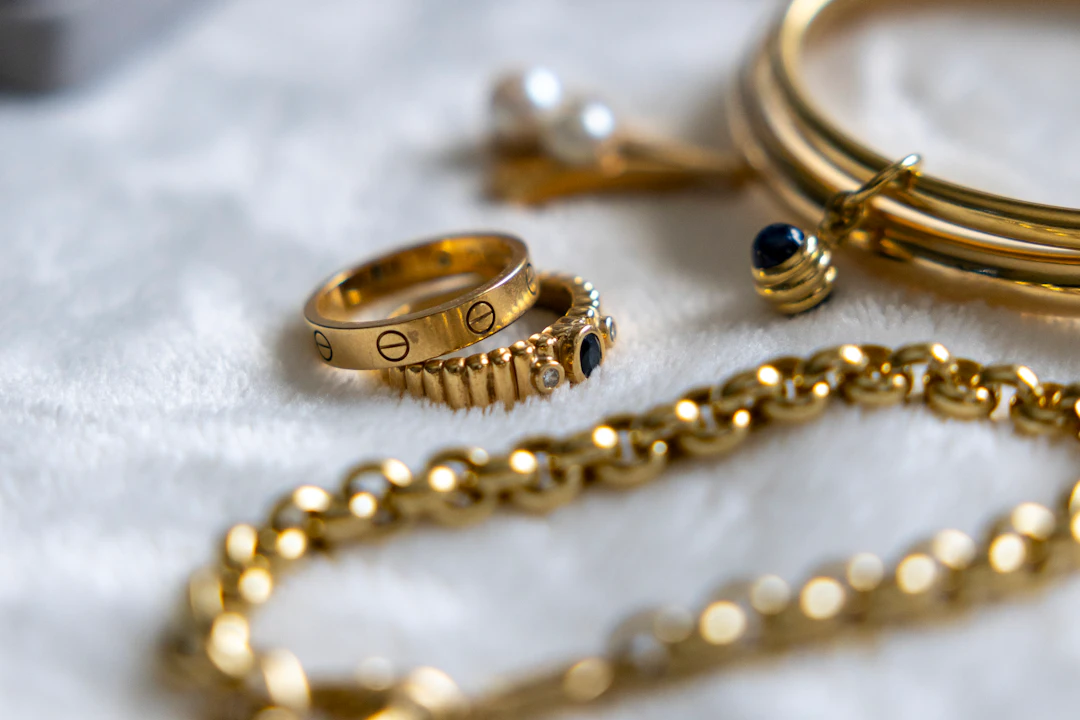 Golden jewelry pieces arranged on a soft surface — layering essentials for Gemini women