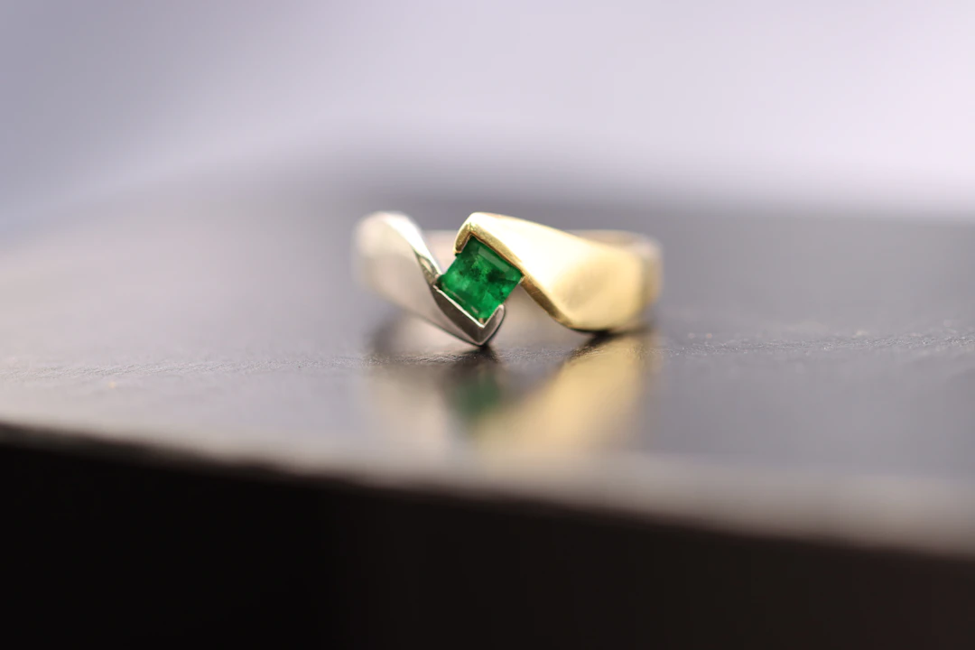 Gold ring with a green emerald stone — the May birthstone for Taurus women
