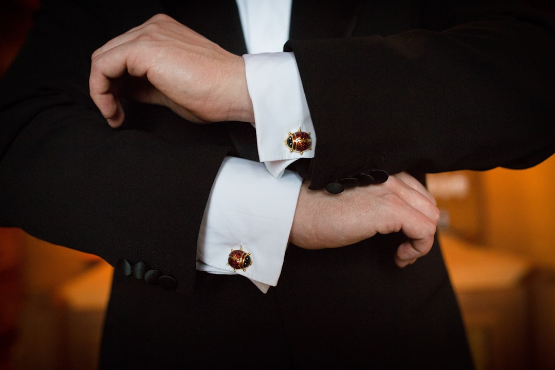 Groom fastening statement cufflinks on a wedding suit — luxury cufflinks as a wedding gift