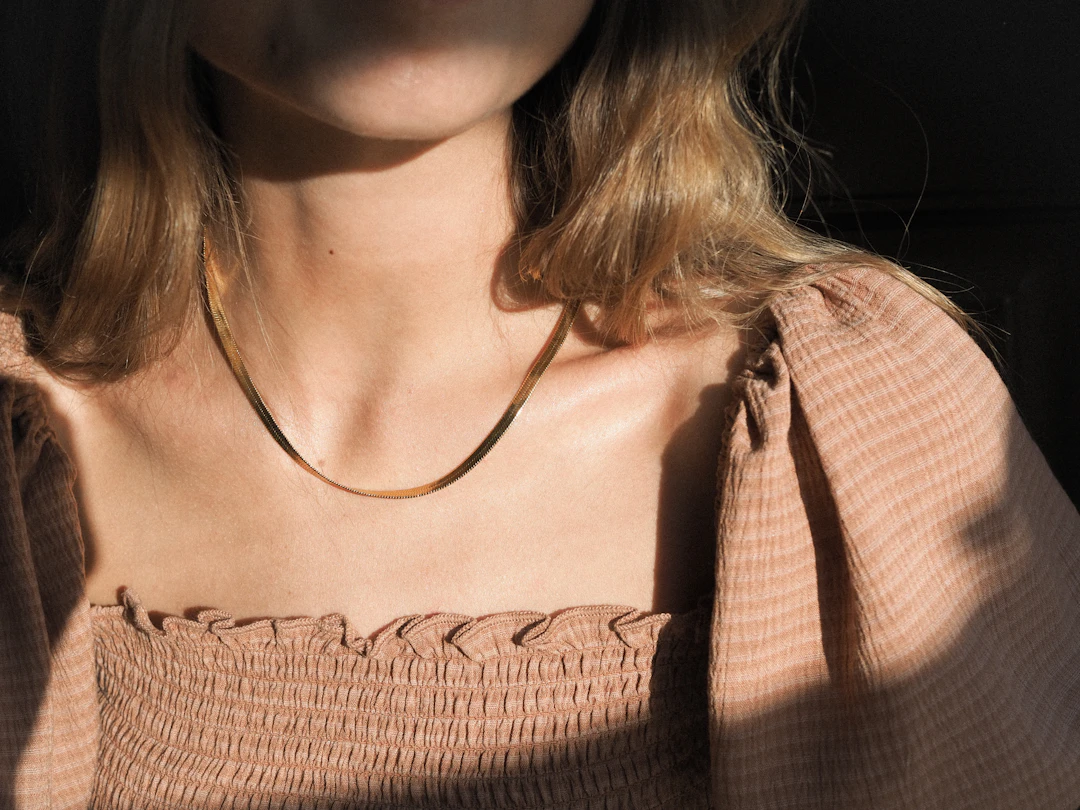 Woman wearing a gold necklace — solid gold everyday jewelry gifts for Taurus women