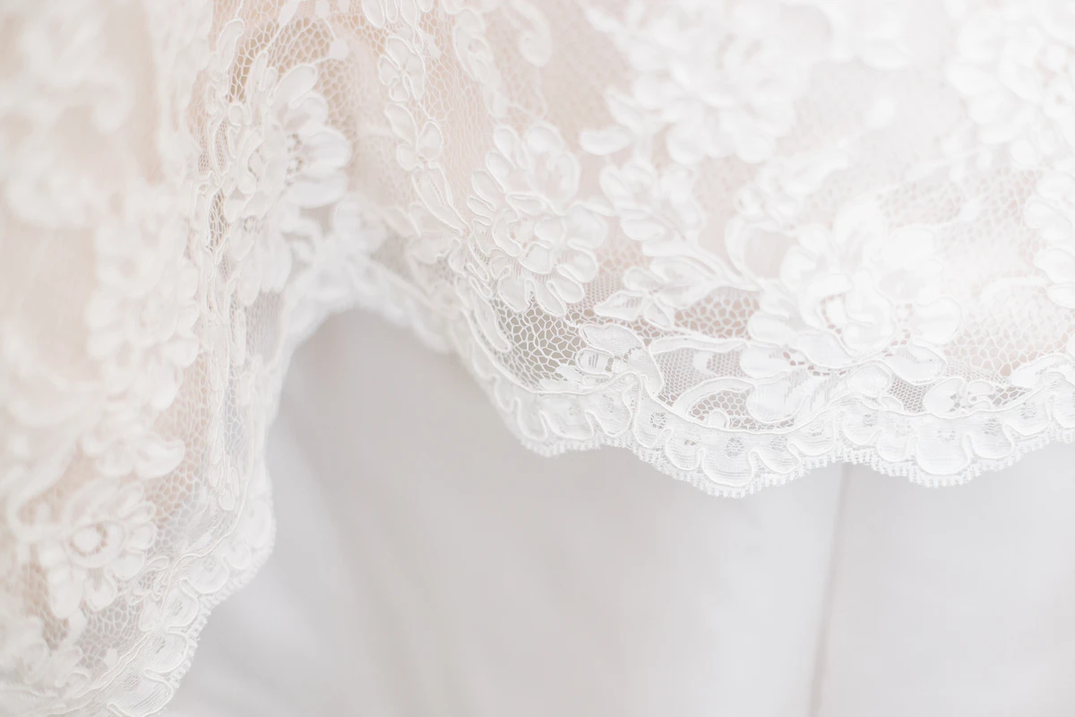 Close-up of lace and beadwork fabric detail on a wedding dress