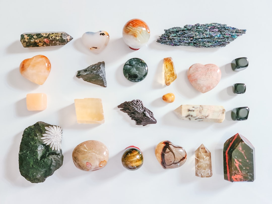 Assorted colorful zodiac gemstones and crystals arranged on a white table