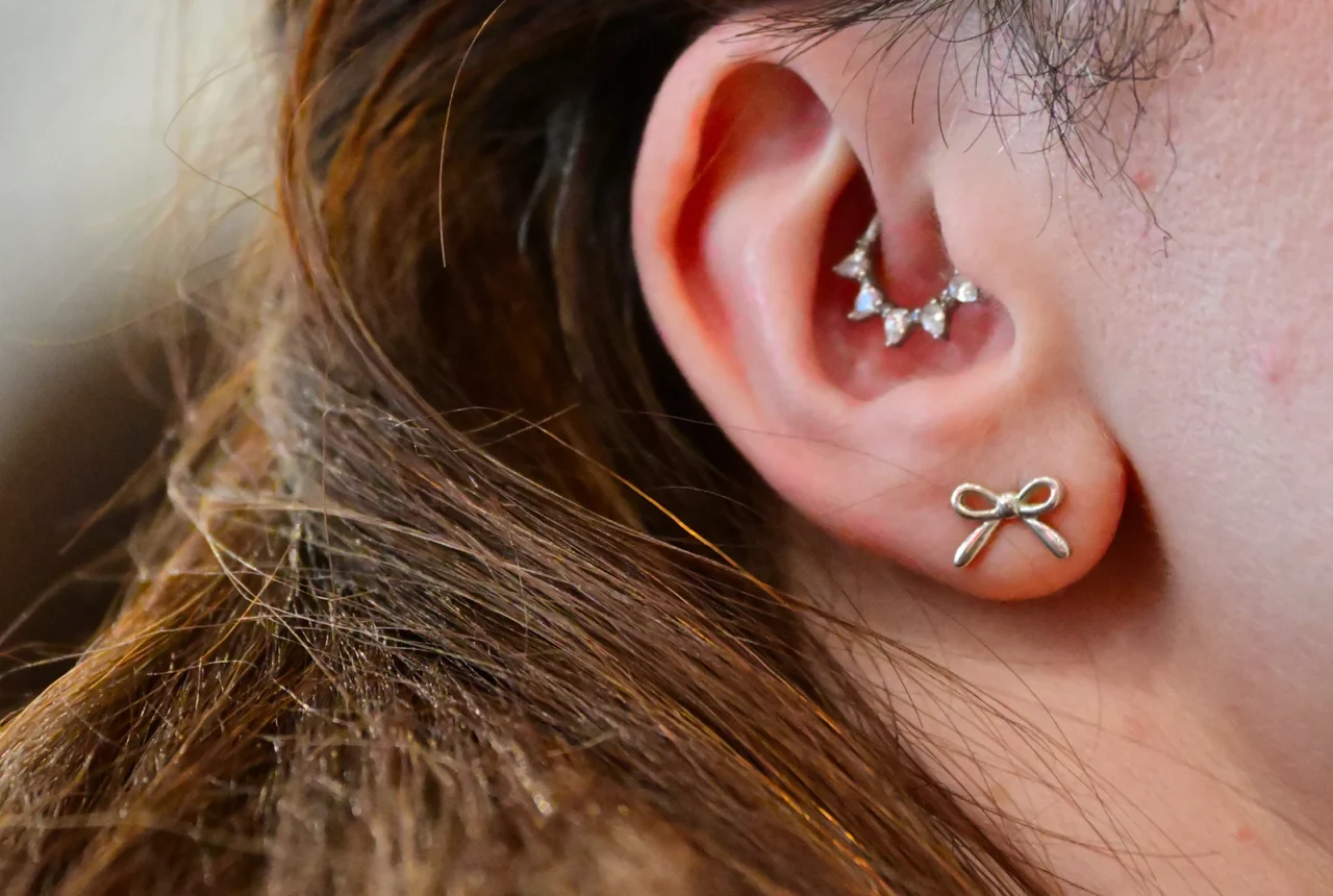 Close up of an ear with several piercings showing lobe and helix placements