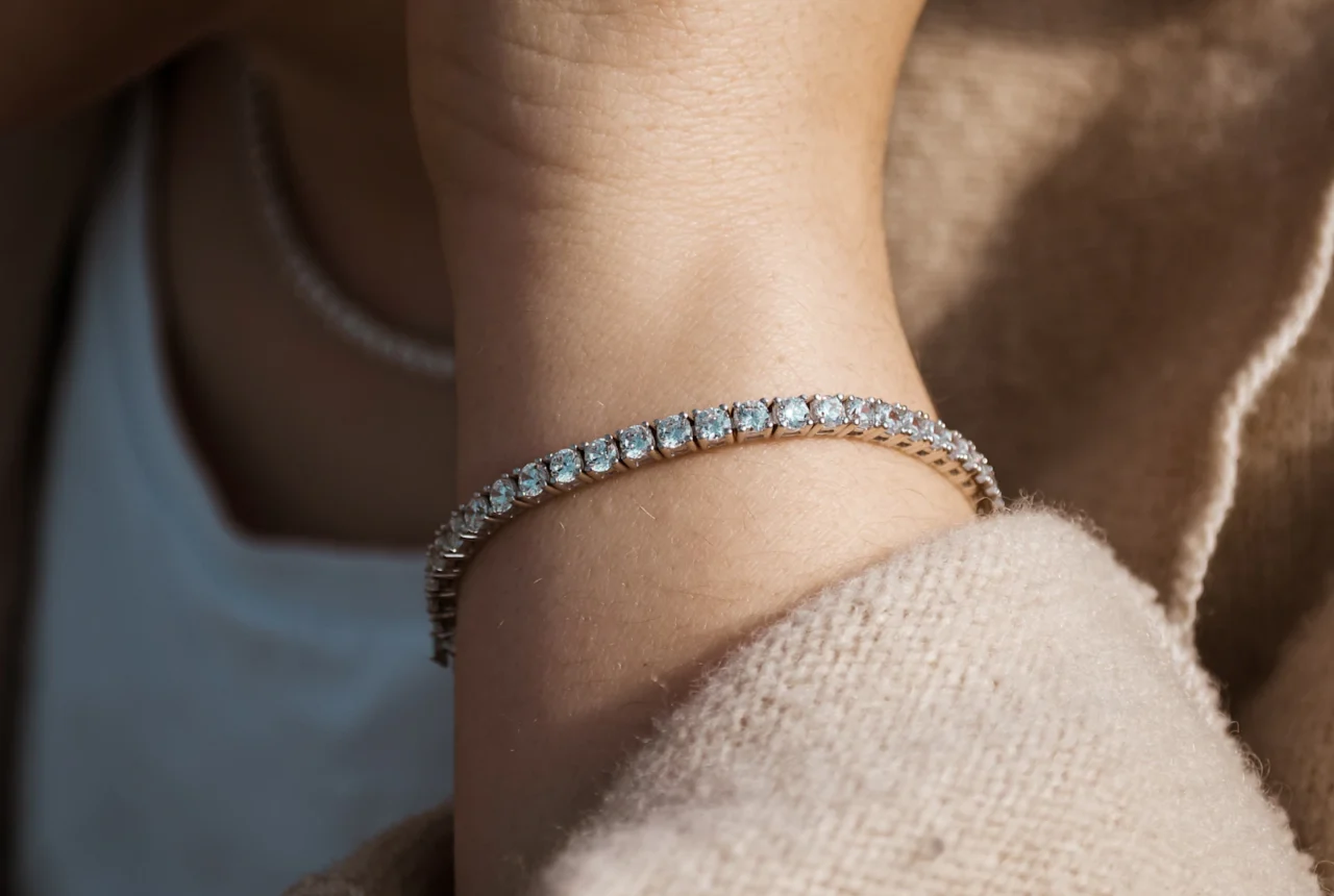 Diamond tennis bracelet worn on a woman wrist, showing a continuous line of matched round stones